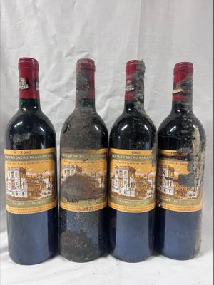 four bottles of wine are lined up in a row on a table