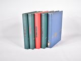 trois livres sont empilés sur une surface blanche