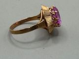 an image of a gold ring with a pink stone in the center