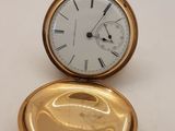 une image représentant une montre de poche en or posée sur une table blanche