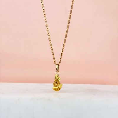 un collier plaqué or orné d'une minuscule pierre jaune montée sur une chaîne