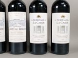 three bottles of red wine are lined up on a table