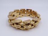 a close up of a gold bracelet on a white surface