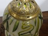 a small vase with a gold lid sitting on a table