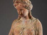 a statue of a woman holding a flower in her hand