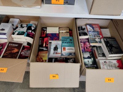 Des cartons de livres sont empilés sur une étagère dans une librairie