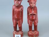 paire de figurines rouges sculptées représentant un singe et un homme-singe