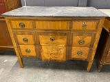 a wooden dresser with marble top in a room