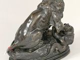 bronze statue of a lion on a rock on a white background