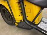 a close up of a yellow motorcycle parked in a parking lot