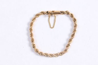 gros plan d'un bracelet en or avec une chaîne sur fond blanc