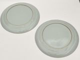 two plates sitting on a table with a white surface