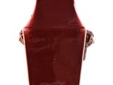 a red vase that is sitting on a white surface
