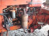 a rusted engine of a tractor parked in the dirt