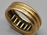 a close up of a gold ring on a gray surface