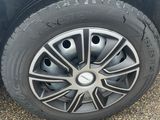 a close up of a tire on a white car with a black rim