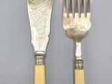 two forks and a knife are sitting next to each other