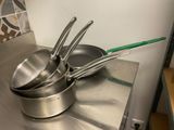 des casseroles et des poêles posées sur une cuisinière dans une cuisine