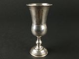 une coupe en argent posée sur une table noire