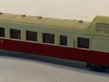 a red and white train on the tracks on a white surface