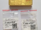 deux lingots d'or et un bout de papier sur lequel figure un code QR