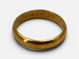 un gros plan d'une bague en or sur laquelle sont gravés les mots « Patrick Street »