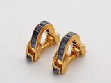 une paire de boucles d'oreilles en or et saphir bleu sur fond blanc
