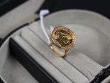 a ring with a gold coin in it in a case