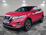 une Nissan QX-V rouge garée sur un sol à damier