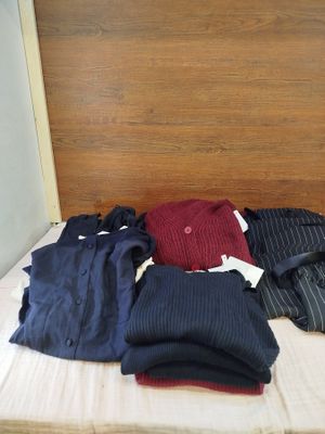 un lit sur lequel sont posés tout un tas de vêtements