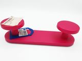 un objet rose muni d'une poignée bleue posé sur une surface blanche