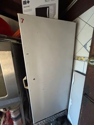 un réfrigérateur dans un coin de la cuisine, à côté d'une cuisinière