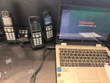 a laptop, phone, and other electronic devices on a table