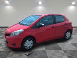 a red car is parked in a room with a checkered floor