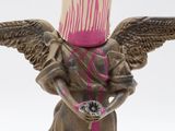 a statue of an angel with a can on his head
