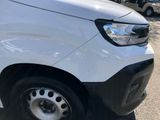 the front end of a white van parked in a parking lot