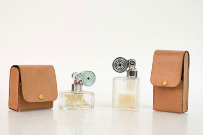 trois petits flacons de parfum et un étui posés sur la table