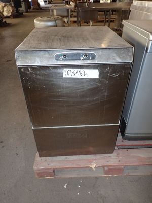 un lave-vaisselle argenté posé sur une palette dans un entrepôt