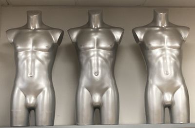 trois mannequins posés sur une étagère dans une pièce