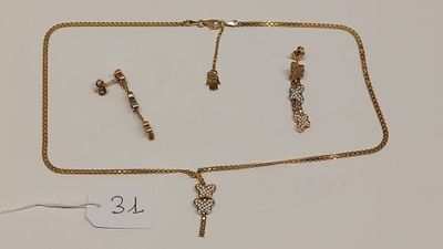 deux colliers en or et une paire de boucles d'oreilles posés sur une surface blanche