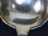 a silver spoon with a handle on a black surface