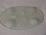 a glass plate with a white design on it on a table