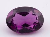 gros plan d'une pierre précieuse violette sur une surface blanche