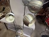 trois lampes posées sur un pied dans une pièce