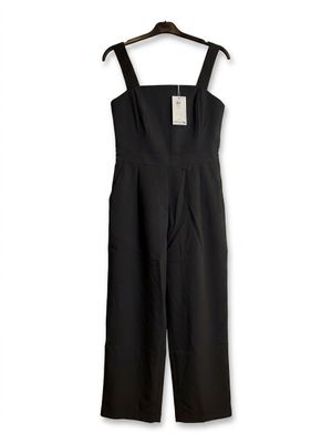 black jumpsuits on a hanger against a white background