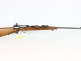a rifle on a white surface with a white background