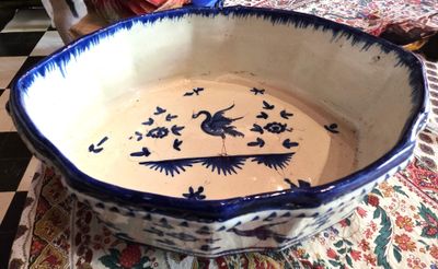 un bol bleu et blanc posé sur une table recouverte d'une nappe rouge et blanche