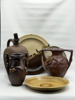 trois vases, une assiette et un bol posés sur une table