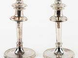 a pair of silver candlesticks on a white background
