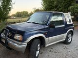 une photo d'un SUV bleu garé sur un parking en gravier